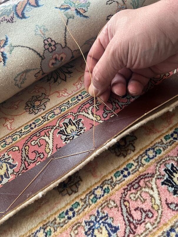 Präzise Handarbeit bei der Kantensanierung eines Tabriz Seidenteppichs – feine Einkettelung und Stabilisierung in Aachen