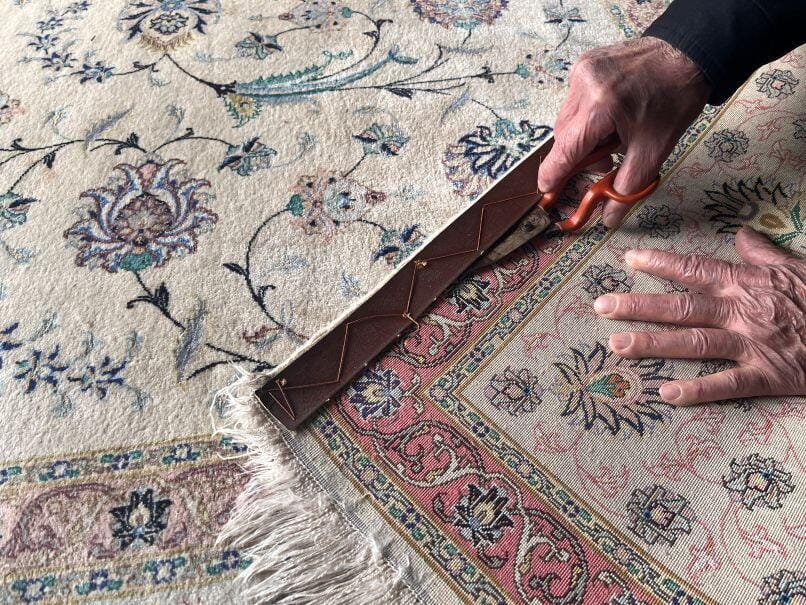 Professionelle Entfernung des alten Kantenschutzes bei der Teppichrestaurierung – Tabriz Seidenteppich in Aachen