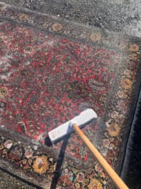 Abkehren der gelösten Schmutzflotte mit weicher Handbürste bei der Ghom Seiden-Teppichveredelung in Aachen